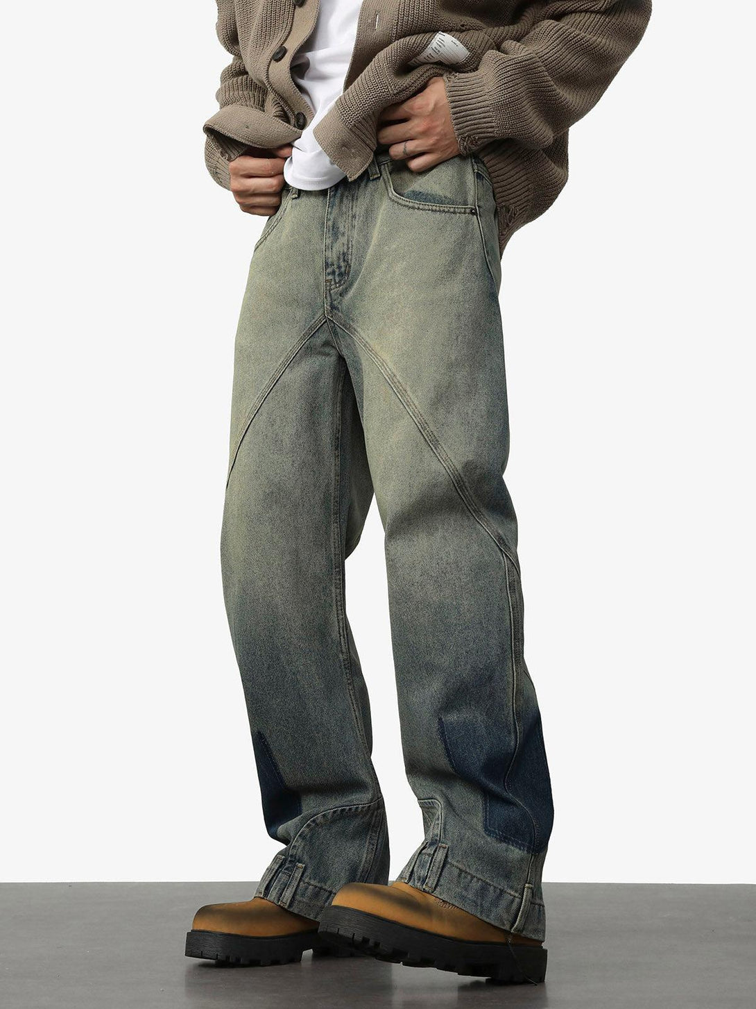 Model wearing TALISHKO deconstructed straight jeans with unique ankle loops and a relaxed fit.