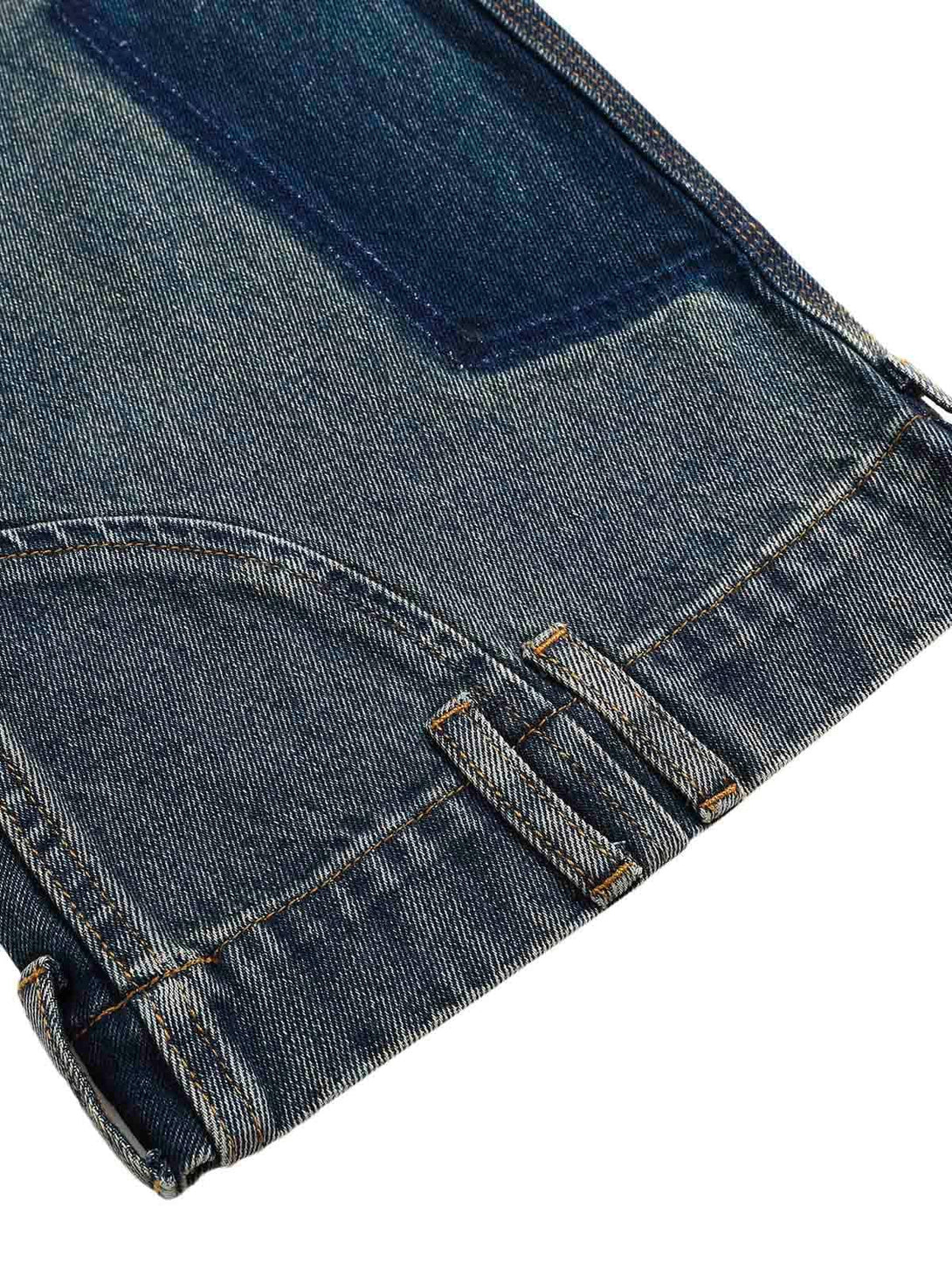 Zoomed-in texture of TALISHKO's deconstructed straight jeans, showcasing ankle loop detail.
