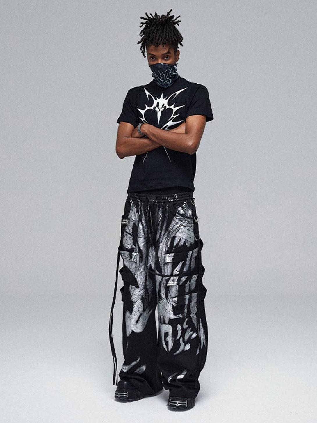 Model showcasing TALISHKO's deconstructed pants with striking silver ribbon details for edgy style.