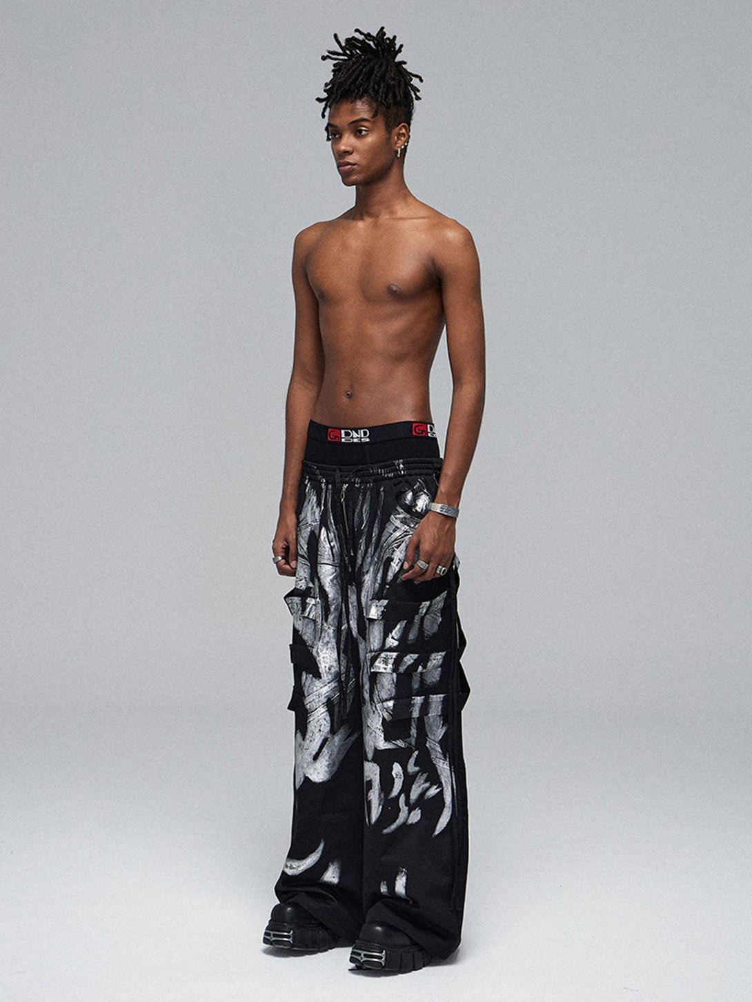 Model in TALISHKO's deconstructed drawstring pants, featuring bold silver ribbon details.