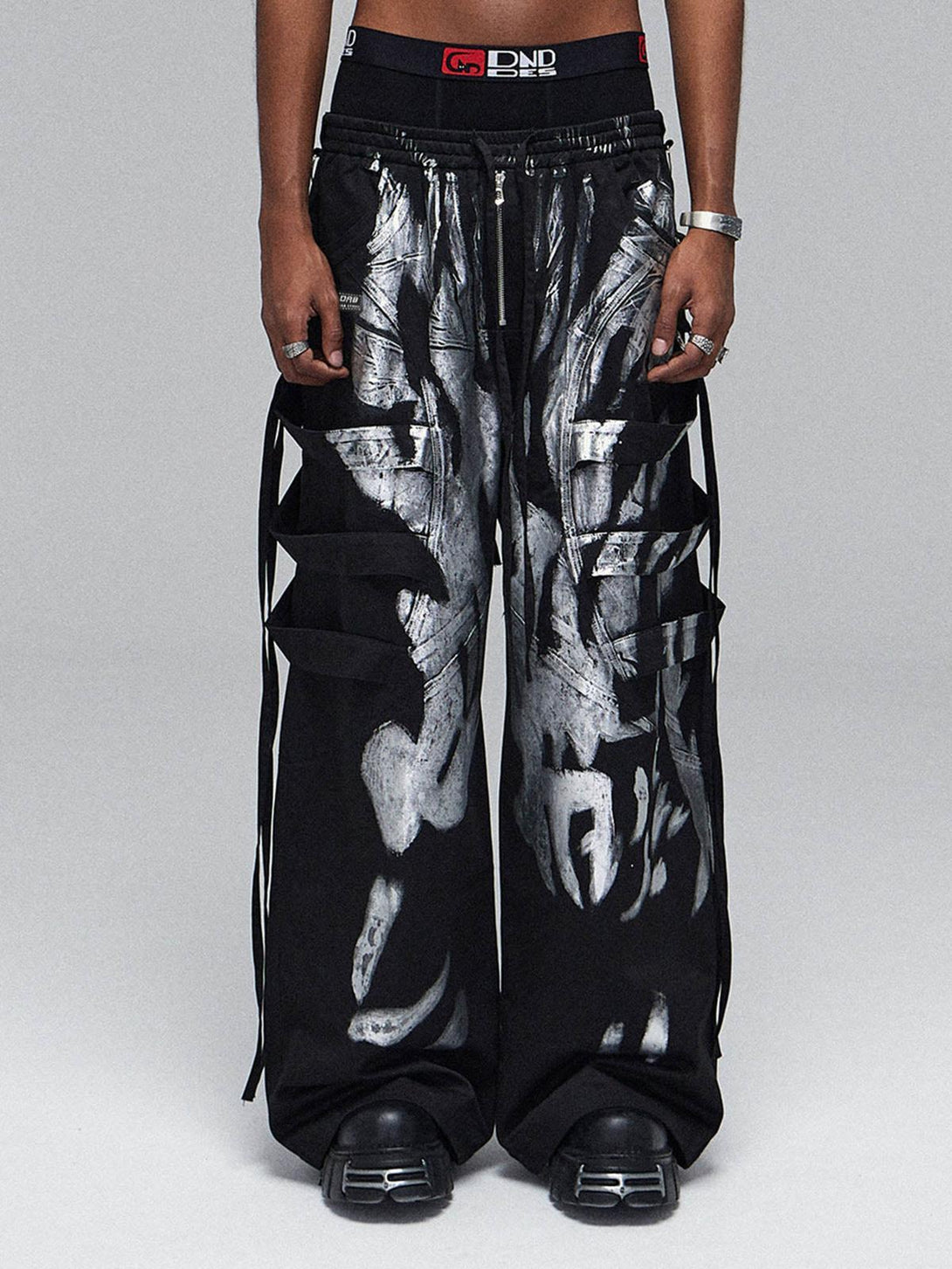 Model wearing TALISHKO's deconstructed drawstring pants with brushed silver accents for a bold style.