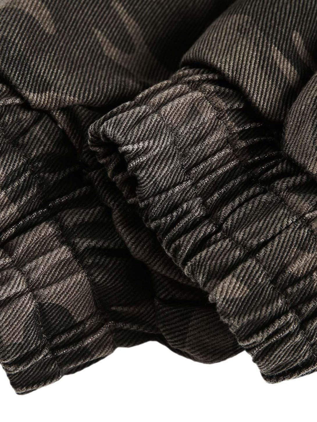 Detailed view of TALISHKO's camouflage jacket sleeve, showcasing the textured fabric.