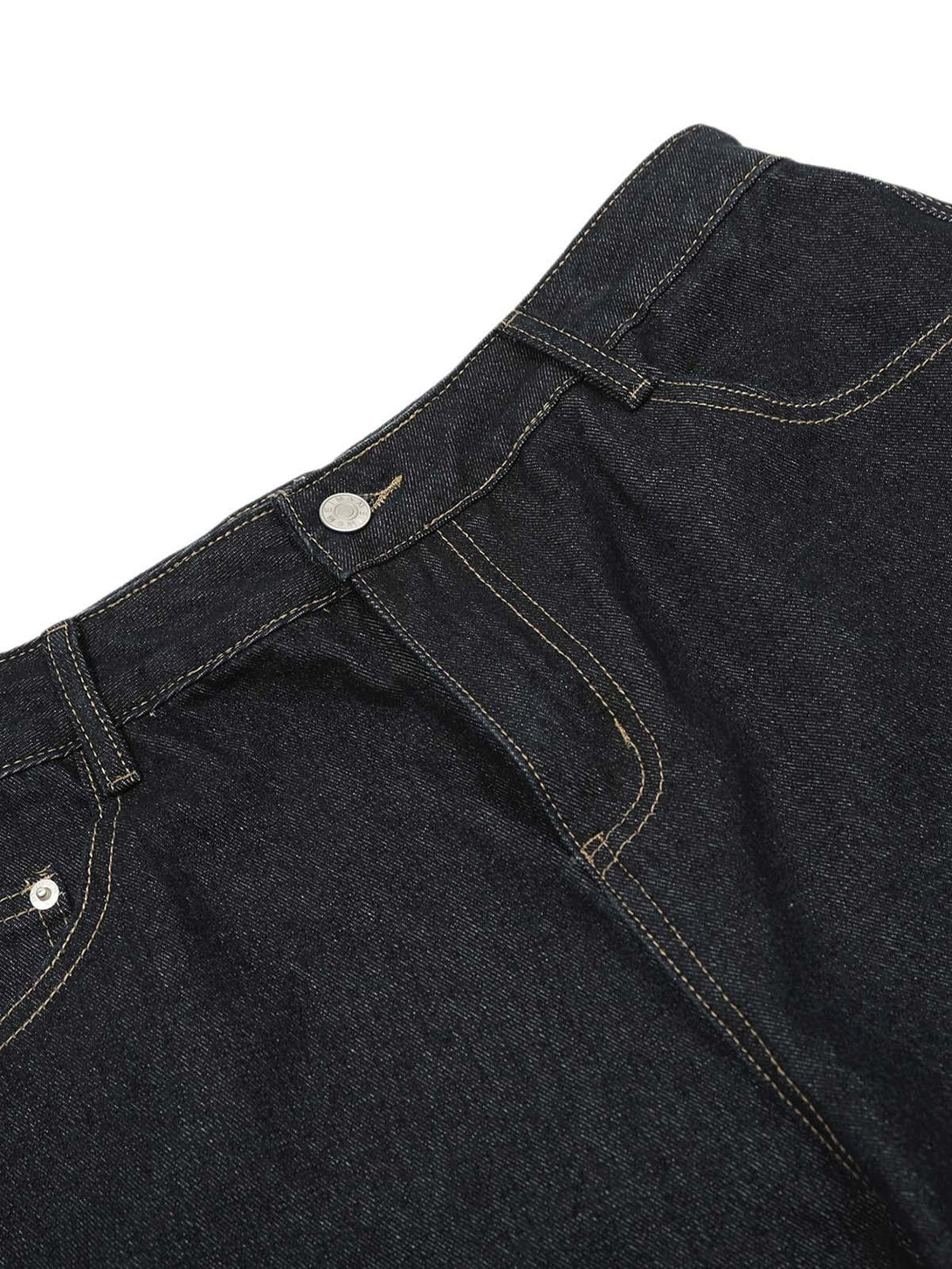 A close-up of TALISHKO's dark denim baggy barrel jeans highlighting stitching details.