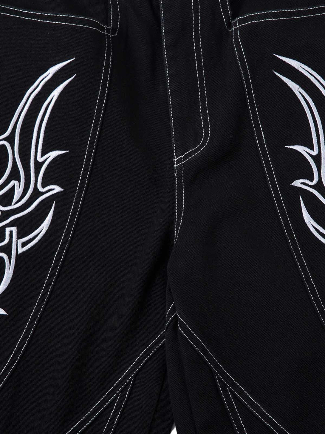 A close-up view of TALISHKO's baggy jeans showcasing detailed embroidery and stitching design.
