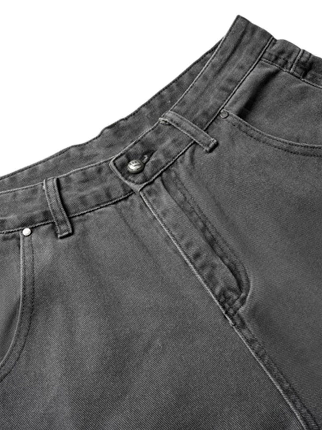 A detailed view of TALISHKO's deconstructed gray cargo jeans, highlighting stitching and texture.