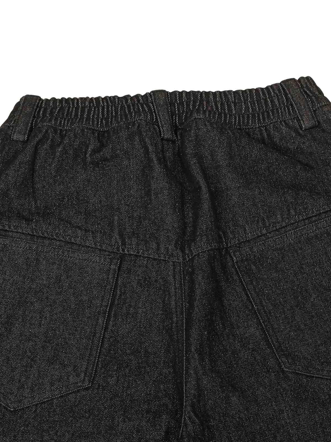 A detailed look at the waistband and pocket design of TALISHKO deconstructed scimitar jeans.