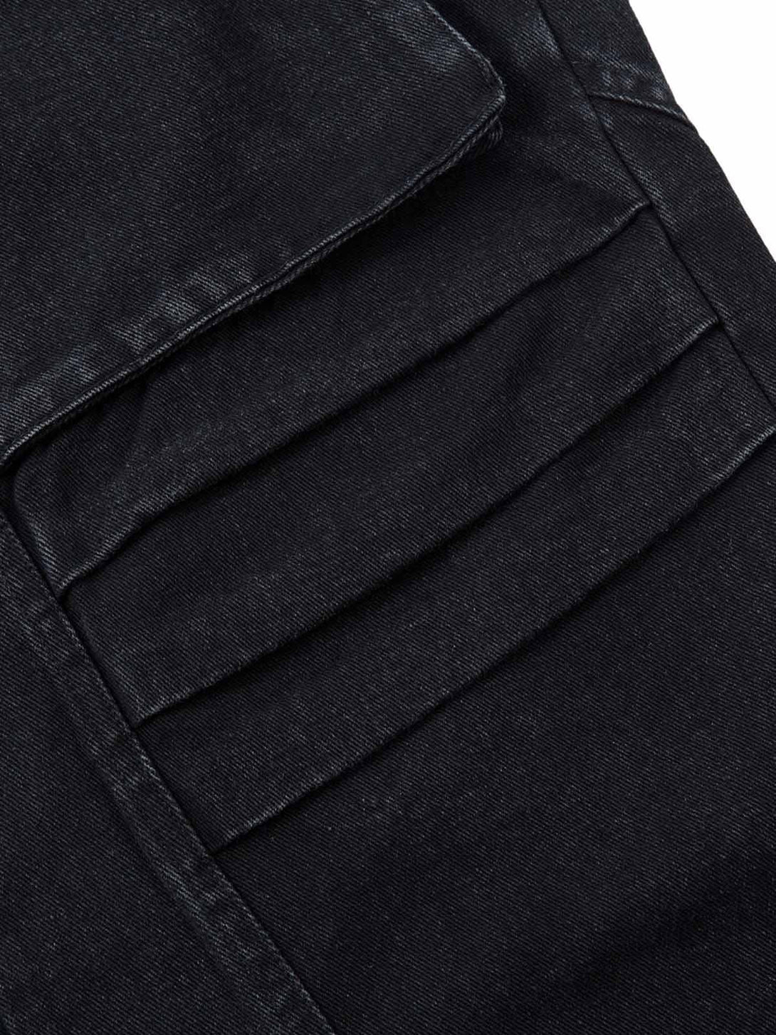 Detailed fabric and stitching on black cargo jeans by TALISHKO, highlighting pleated pocket design.