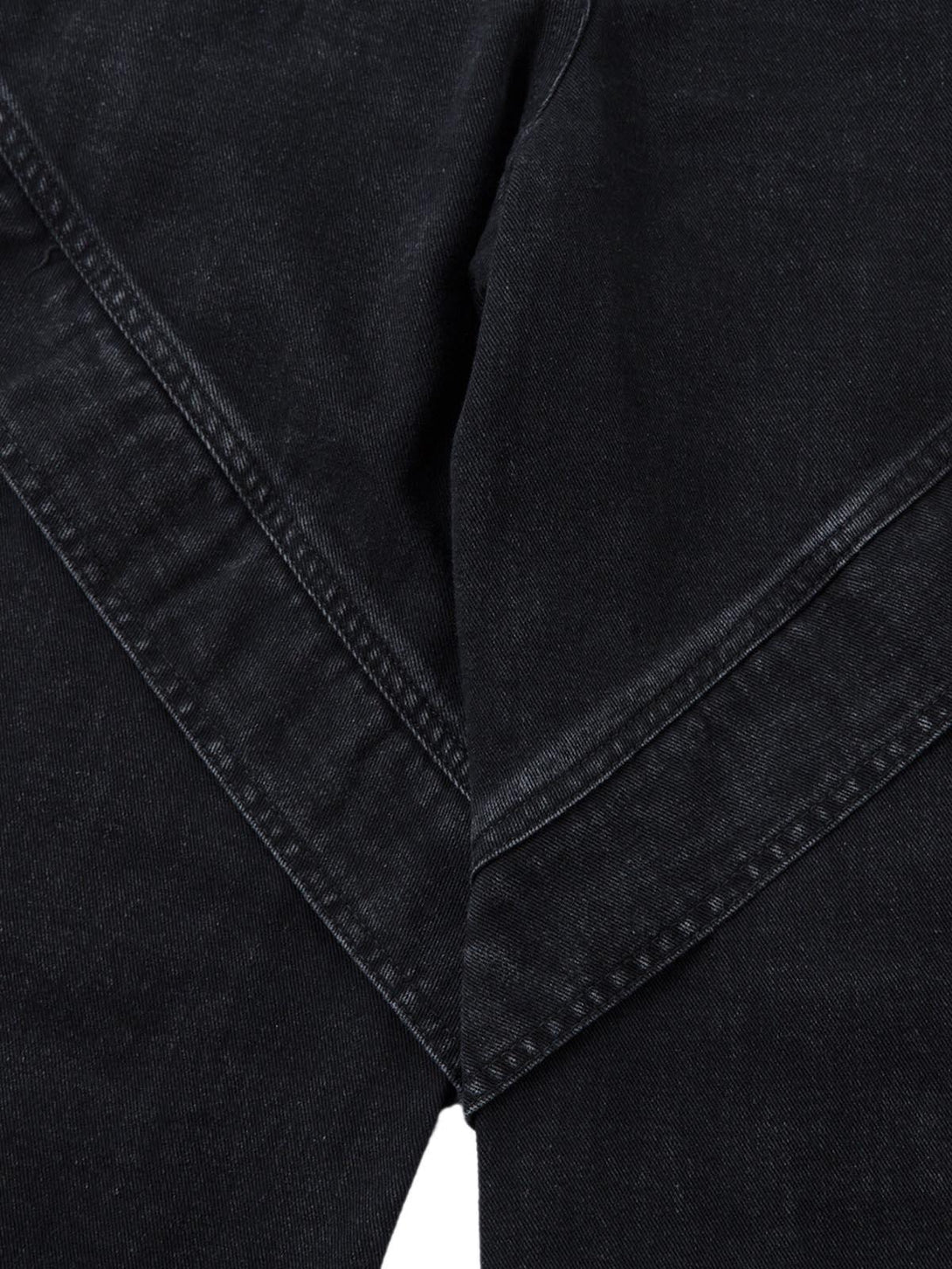 Intricate look at the pleated design and stitching on black cargo jeans by TALISHKO.