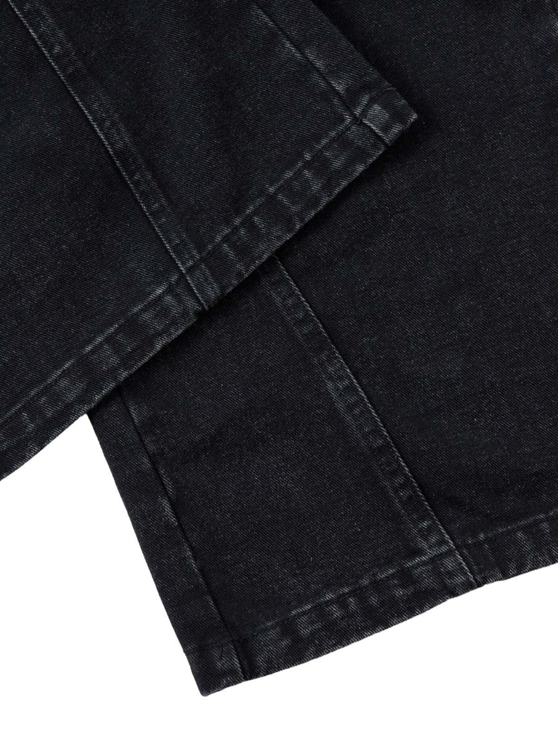 Detailed view of black cargo jeans, showcasing stitching and pleated design by TALISHKO.