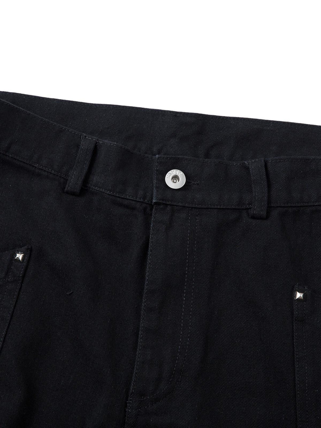 A detailed view of black deconstructed split rivet cargo jeans by TALISHKO, highlighting button closure.