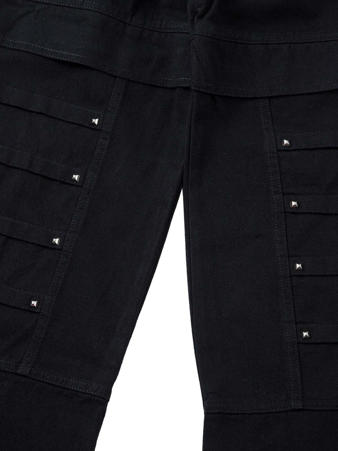 Detailed view of TALISHKO's black cargo jeans, featuring unique rivet and stitching details.