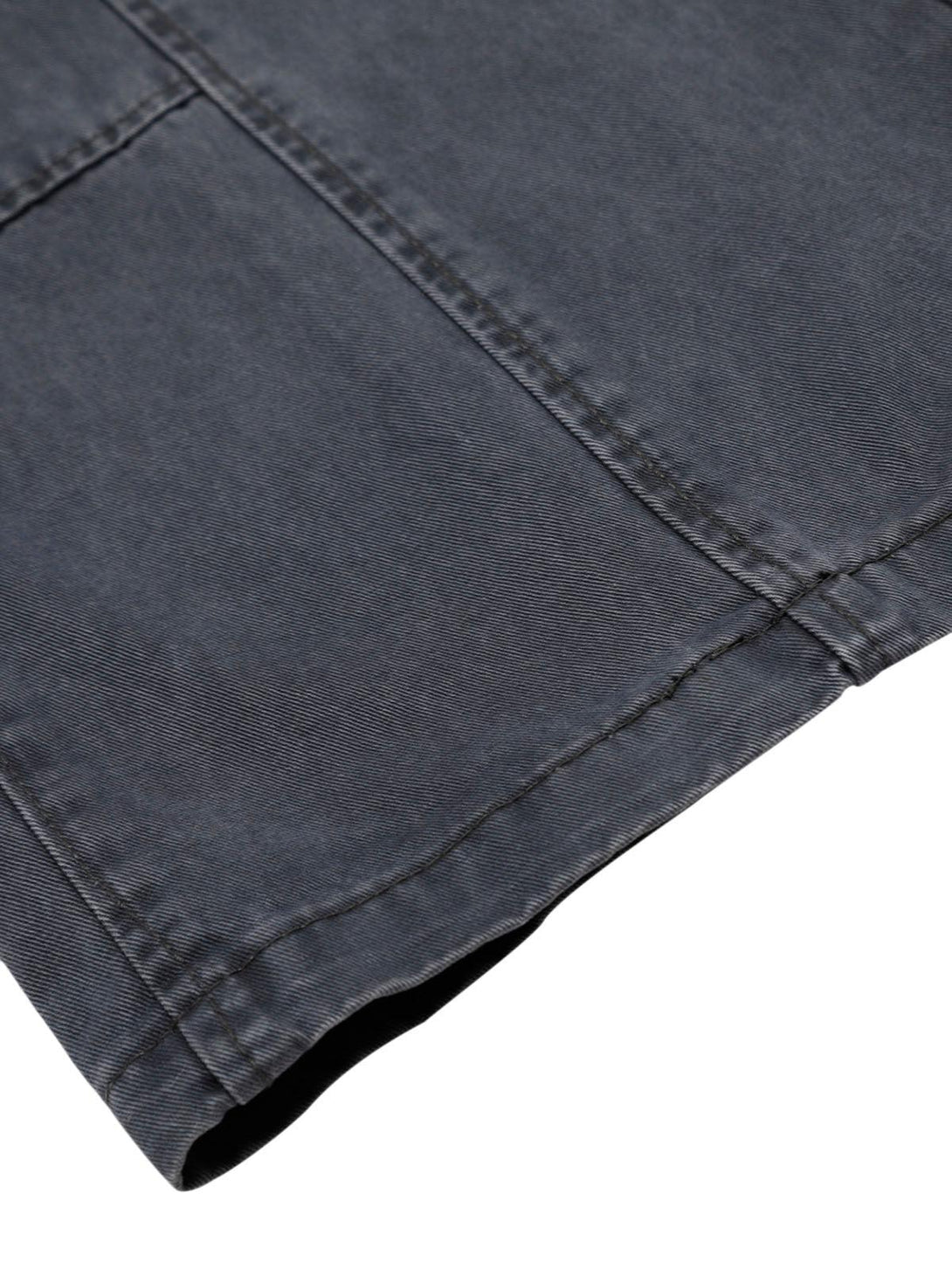Zoomed-in view of TALISHKO deconstructed jeans, highlighting detailed stitching and dark fabric.