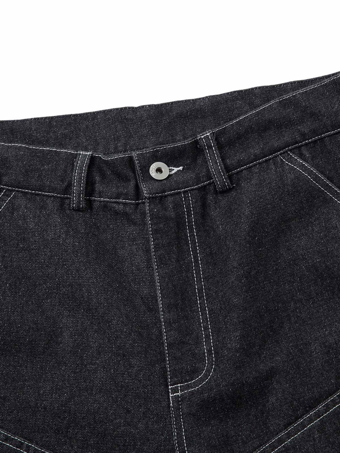 Detailed fabric and stitching on TALISHKO's black jeans, highlighting pleats and topstitching.