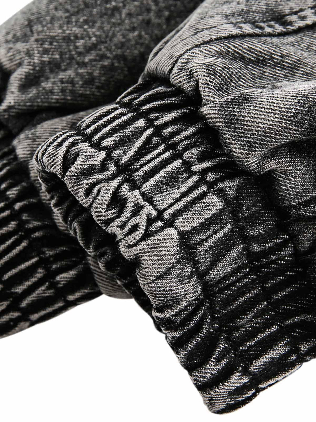 Detailed fabric and stitching of TALISHKO's deconstructed denim jacket, highlighting its texture.