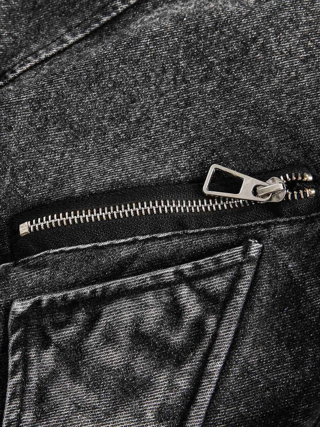 Intricate look at TALISHKO's denim jacket zipper, emphasizing its deconstructed texture.