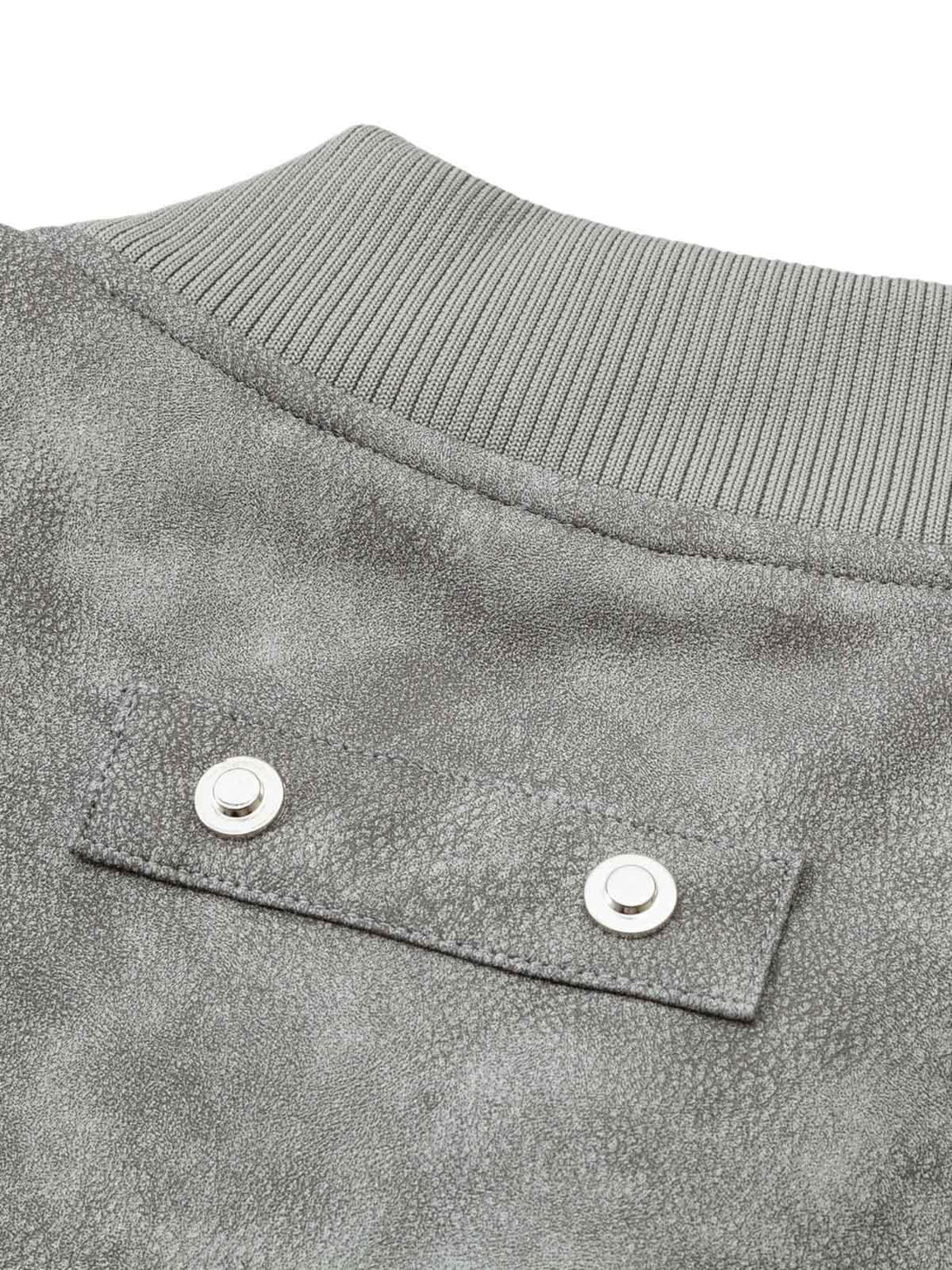 Detailed look at the textured leather and snap details on TALISHKO's bomber jacket.
