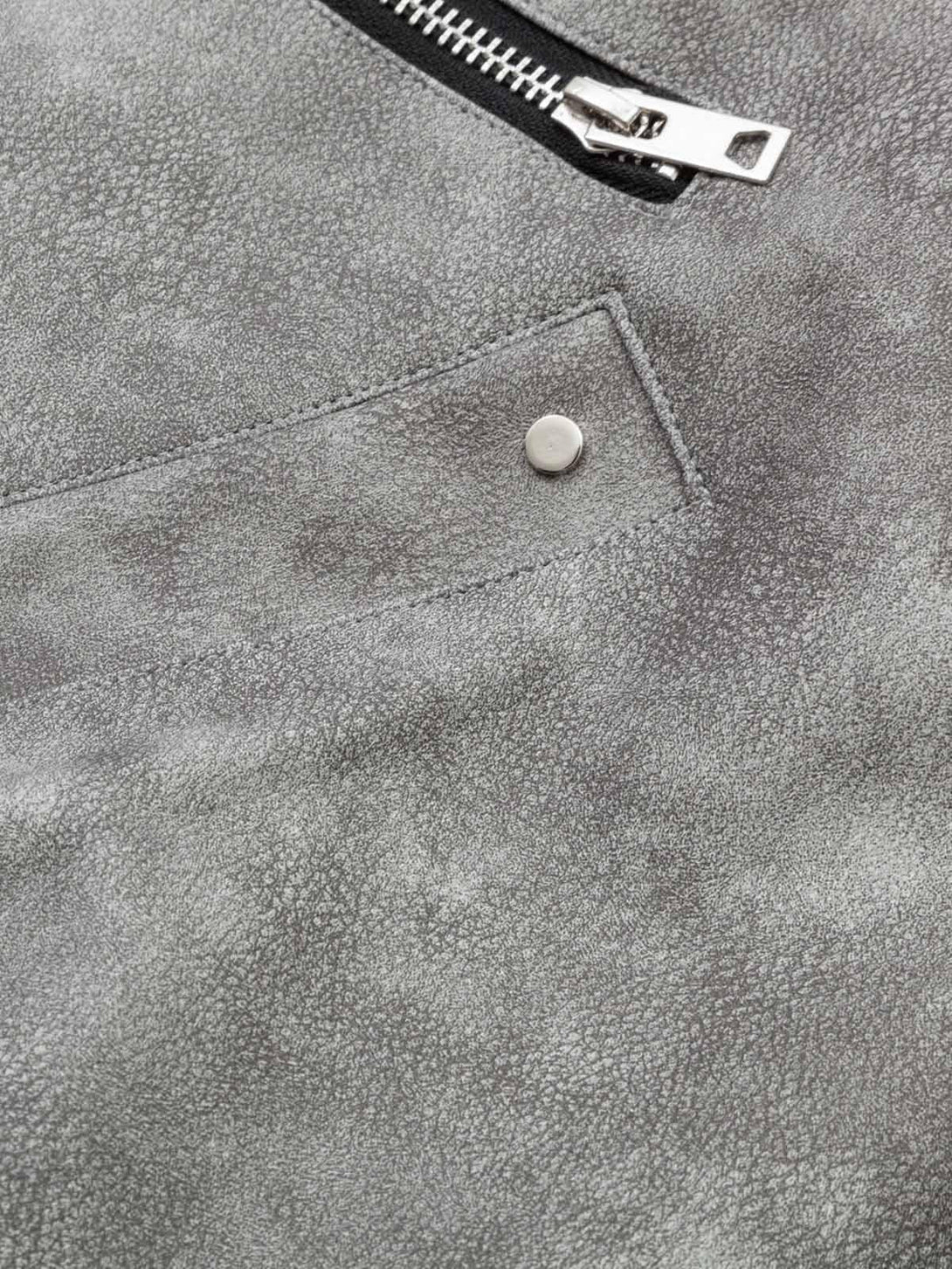 "Textured leather and pocket detail on TALISHKO's bomber jacket, highlighting unique design."