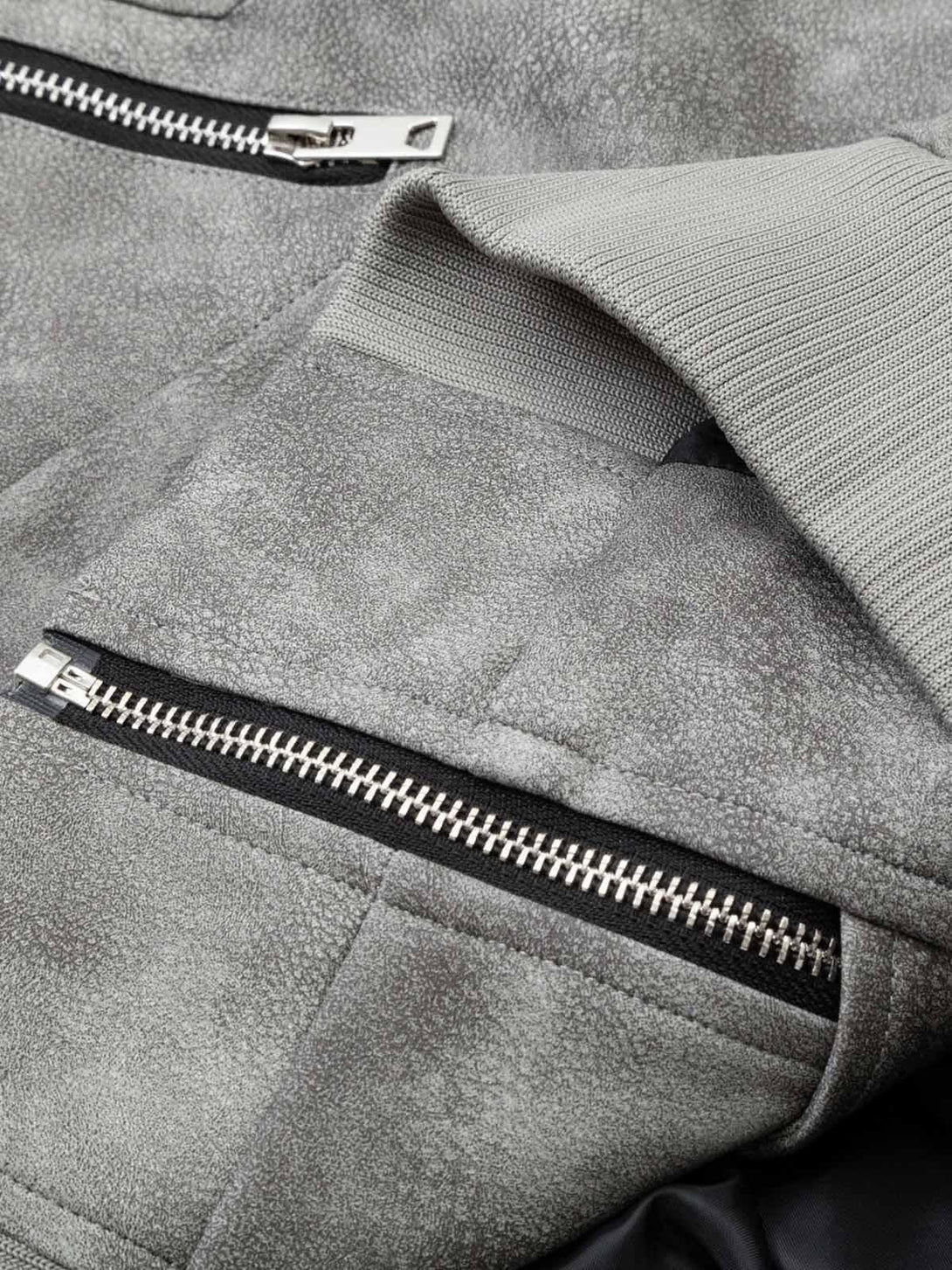 "Focusing on TALISHKO's bomber jacket zipper and textured leather, highlighting unique design."