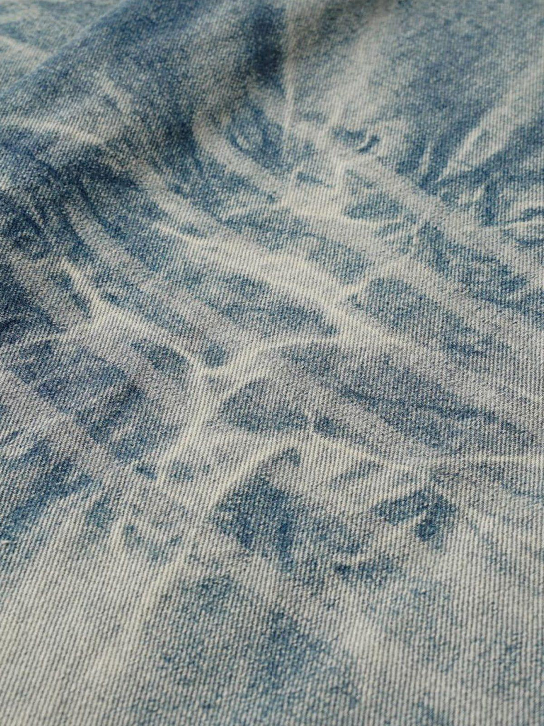 Zoomed-in texture of TALISHKO's deconstruction patchwork jeans, highlighting the intricate fabric design.