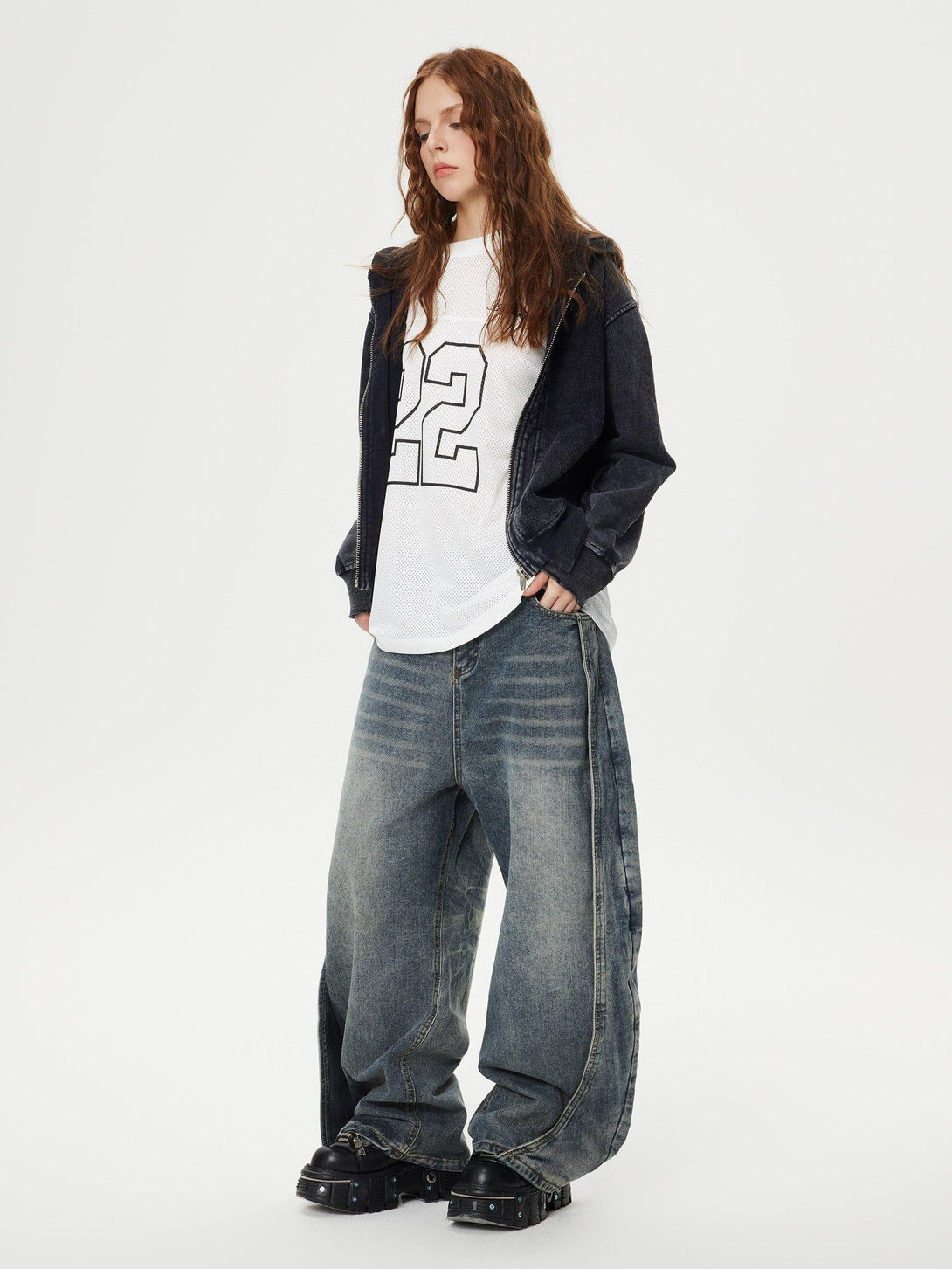 Model pairs TALISHKO's loose deconstruction jeans with a sporty top and dark hoodie.
