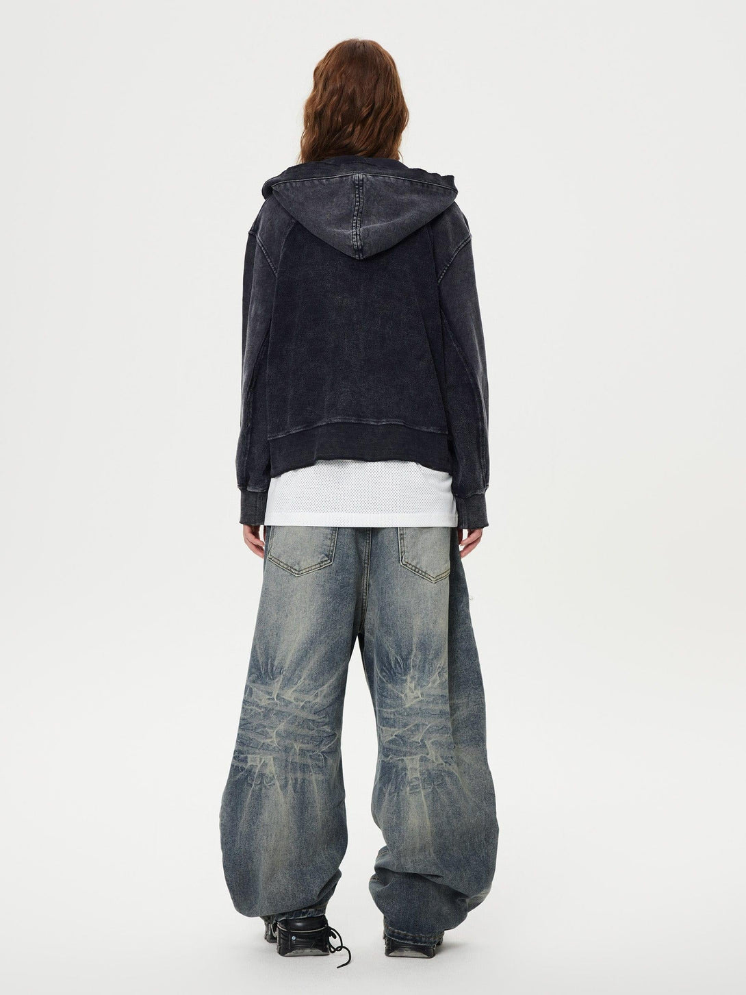 Model showcases TALISHKO's washed loose jeans with a black hoodie, highlighting a relaxed style.