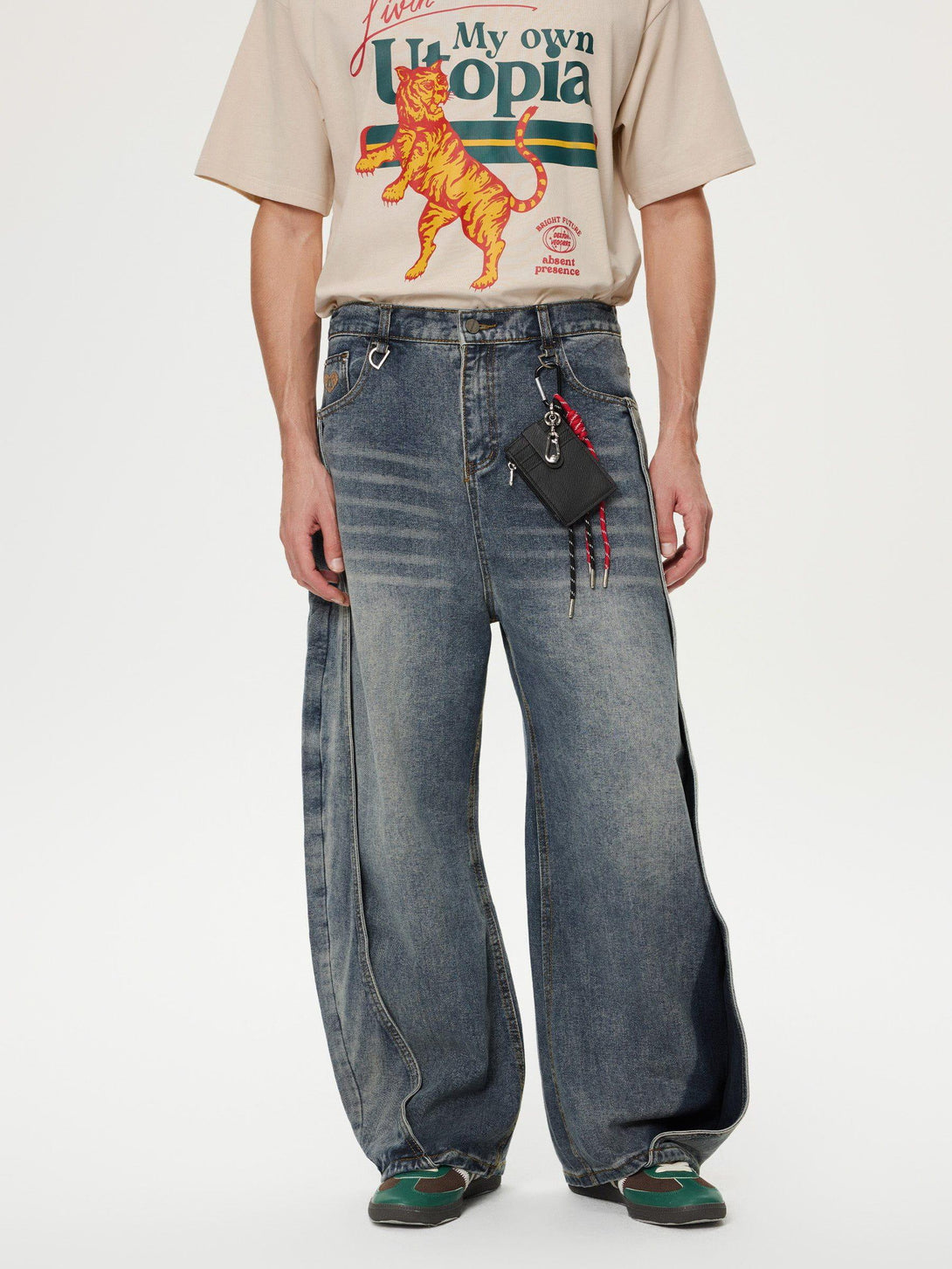 Model in TALISHKO's patchwork washed loose jeans, paired with a graphic tee for a relaxed look.