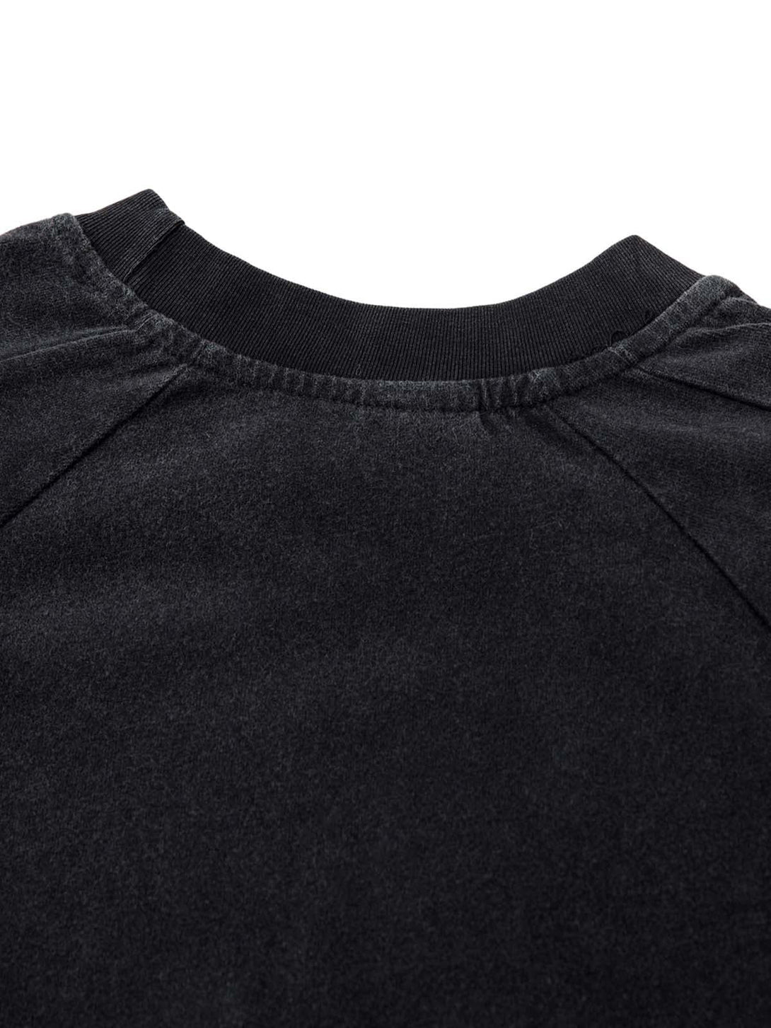 Focusing on the neckline detail of TALISHKO's embroidered T-shirt, showcasing its unique texture.