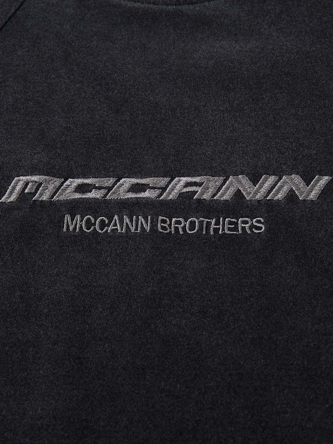 Intricate look at TALISHKO's embroidered T-shirt, focusing on the textured black fabric.