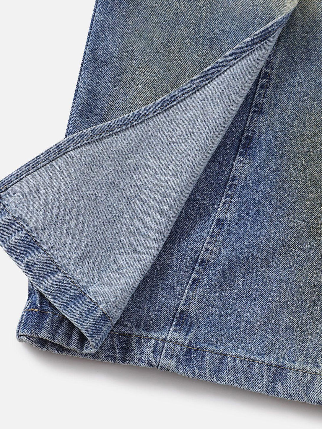 Detailed fabric and stitching of deconstructive patchwork jeans by TALISHKO in blue denim.