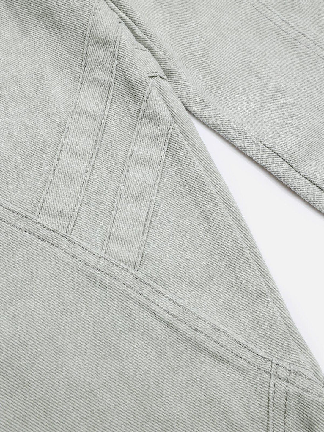 Intricate look at TALISHKO deconstructive patchwork jeans, highlighting detailed stitching.