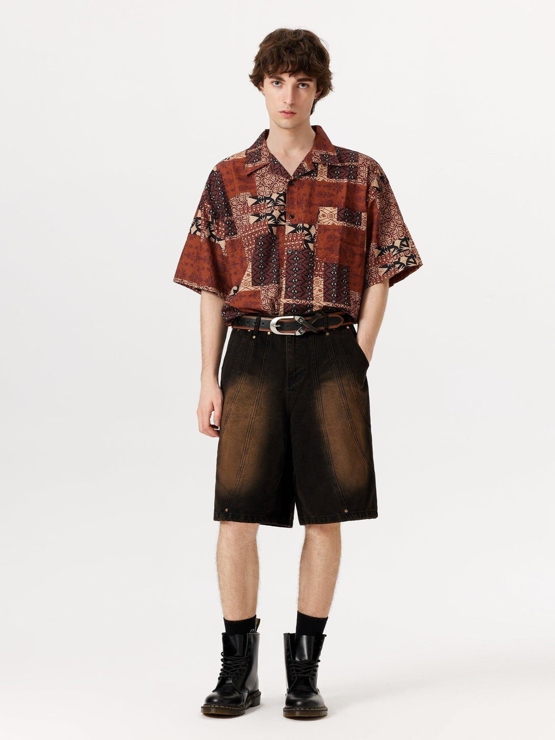 Model in deconstructive washed jorts by TALISHKO, styled with a patterned shirt and boots.