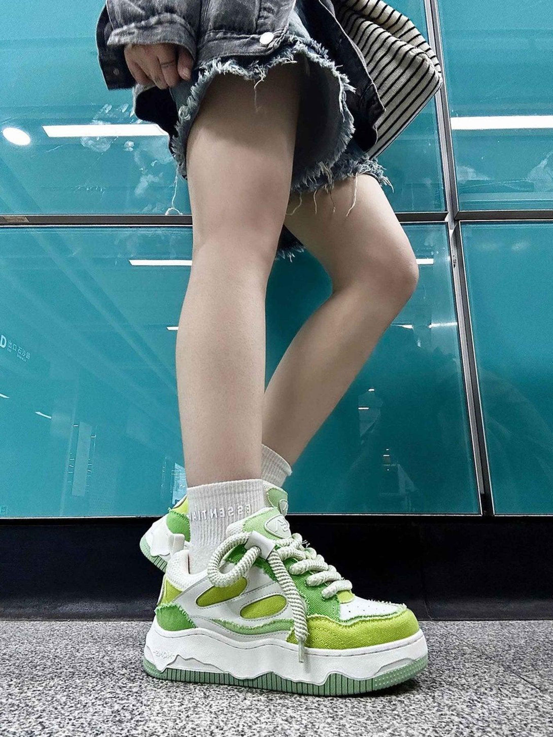 TALISHKO's vibrant green sneakers with thick soles and bold laces add flair to any look.