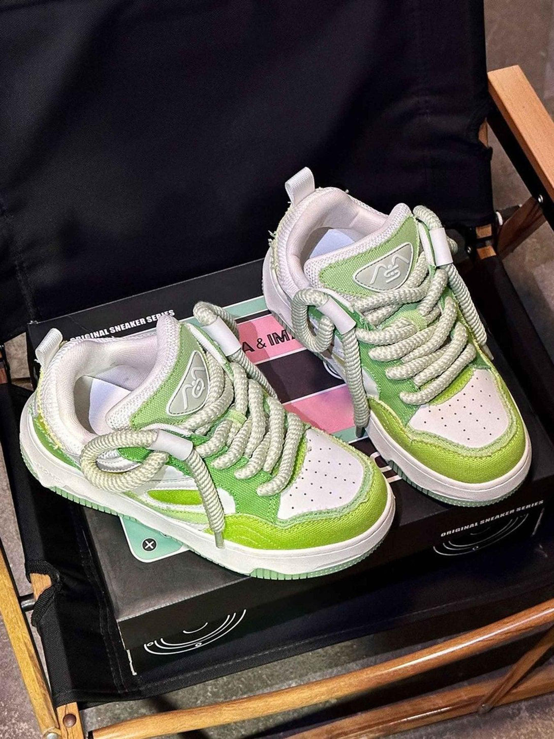 Green and white sneakers by TALISHKO with thick soles and bold laces, great for casual wear.