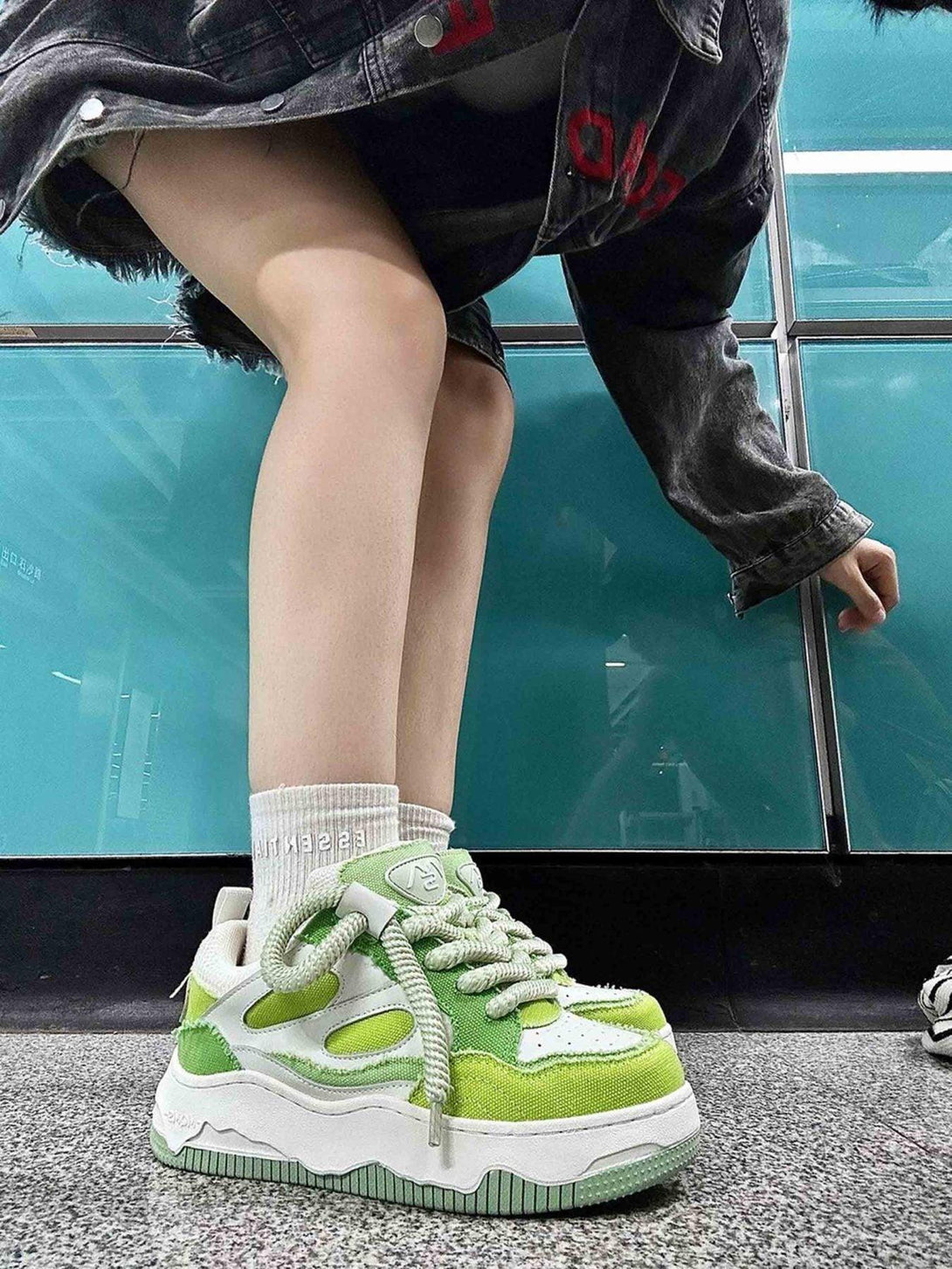 A stylish pair of green thick-soled sneakers by TALISHKO, perfect for bold streetwear fashion.