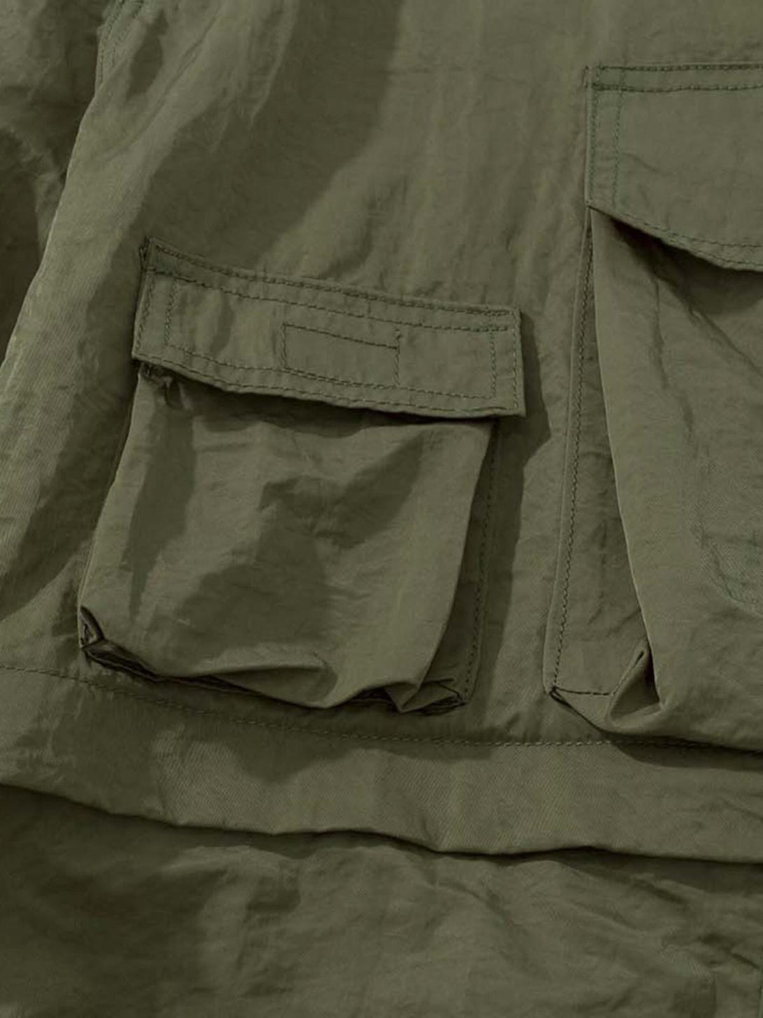 Detailed view of TALISHKO detachable work pants, highlighting olive fabric and pocket design.