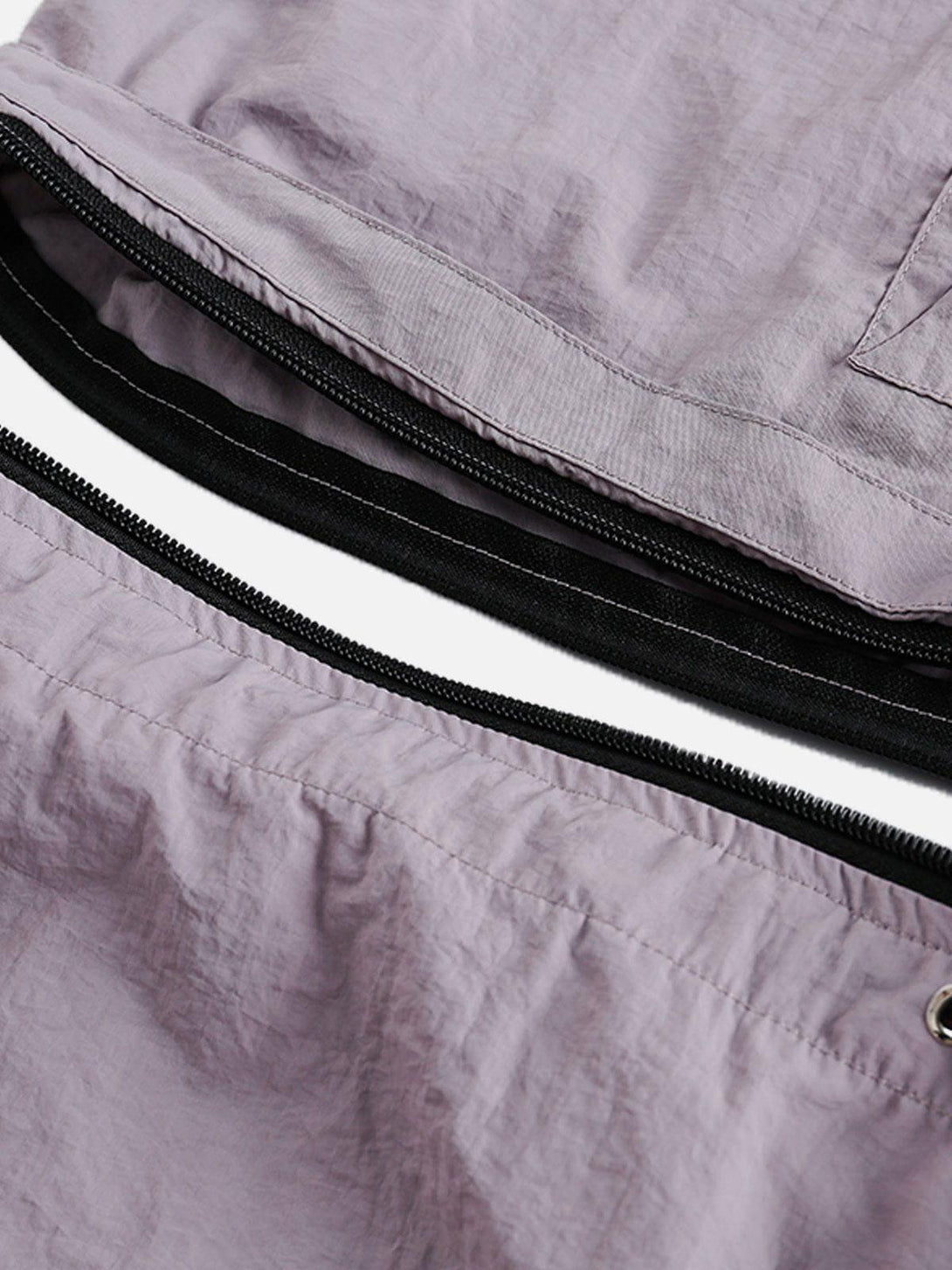 Intricate look at TALISHKO detachable sweatpants, highlighting seamless zipper detail.