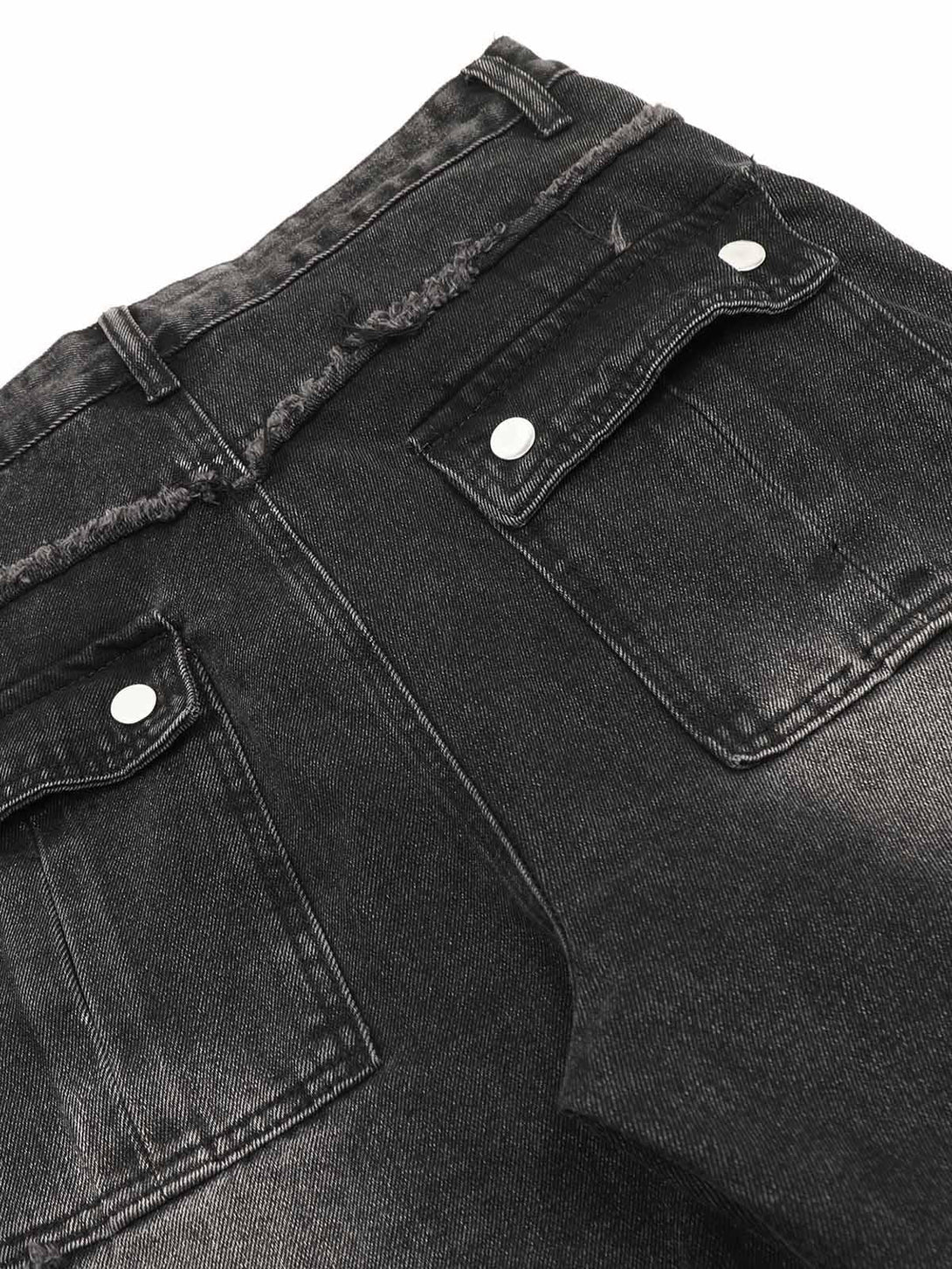 TALISHKO cargo jeans detail, highlighting raw edges and multi-pocket design in black.