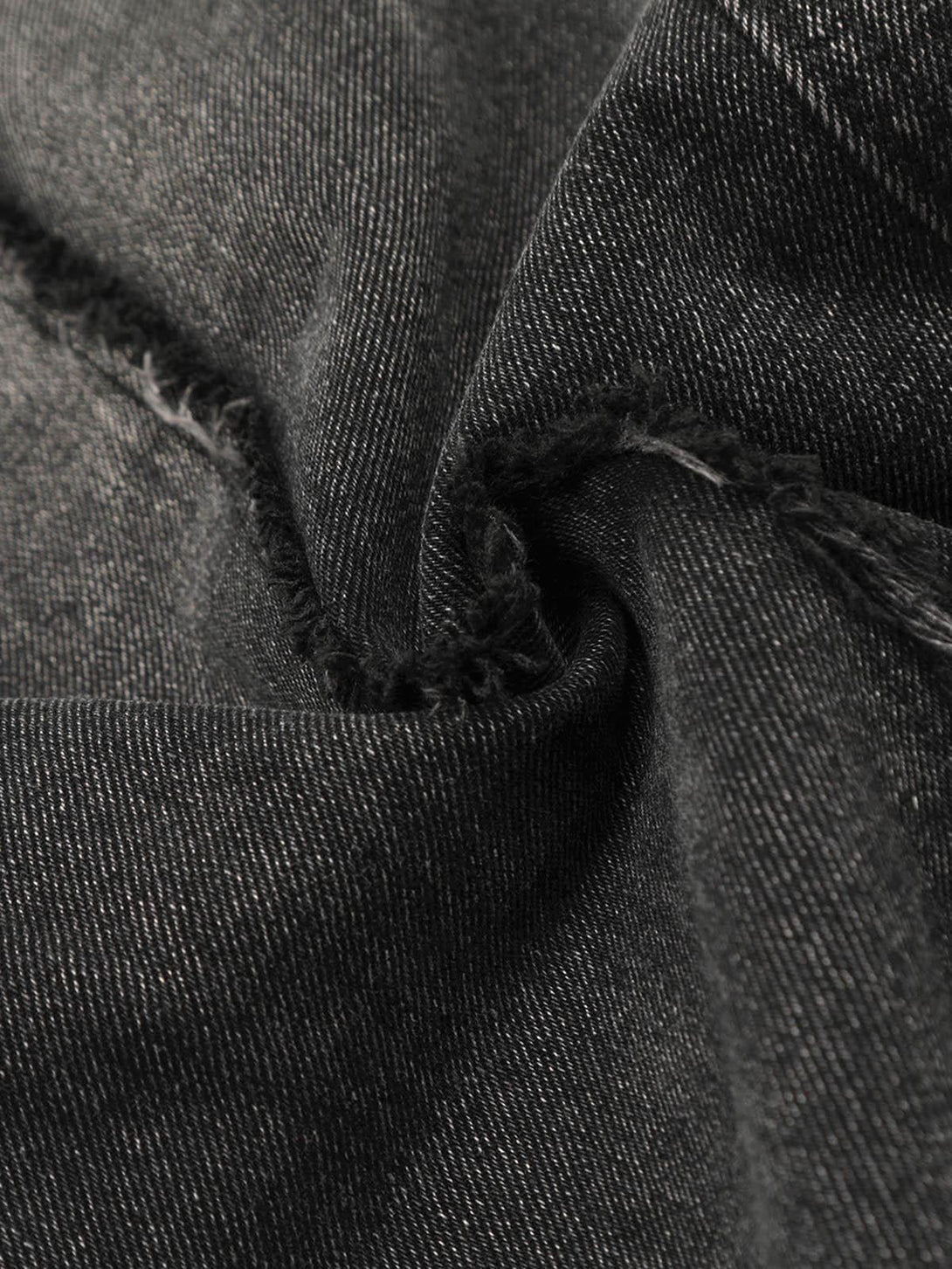 Intricate look at TALISHKO cargo jeans fabric, highlighting distressed texture and raw edges.