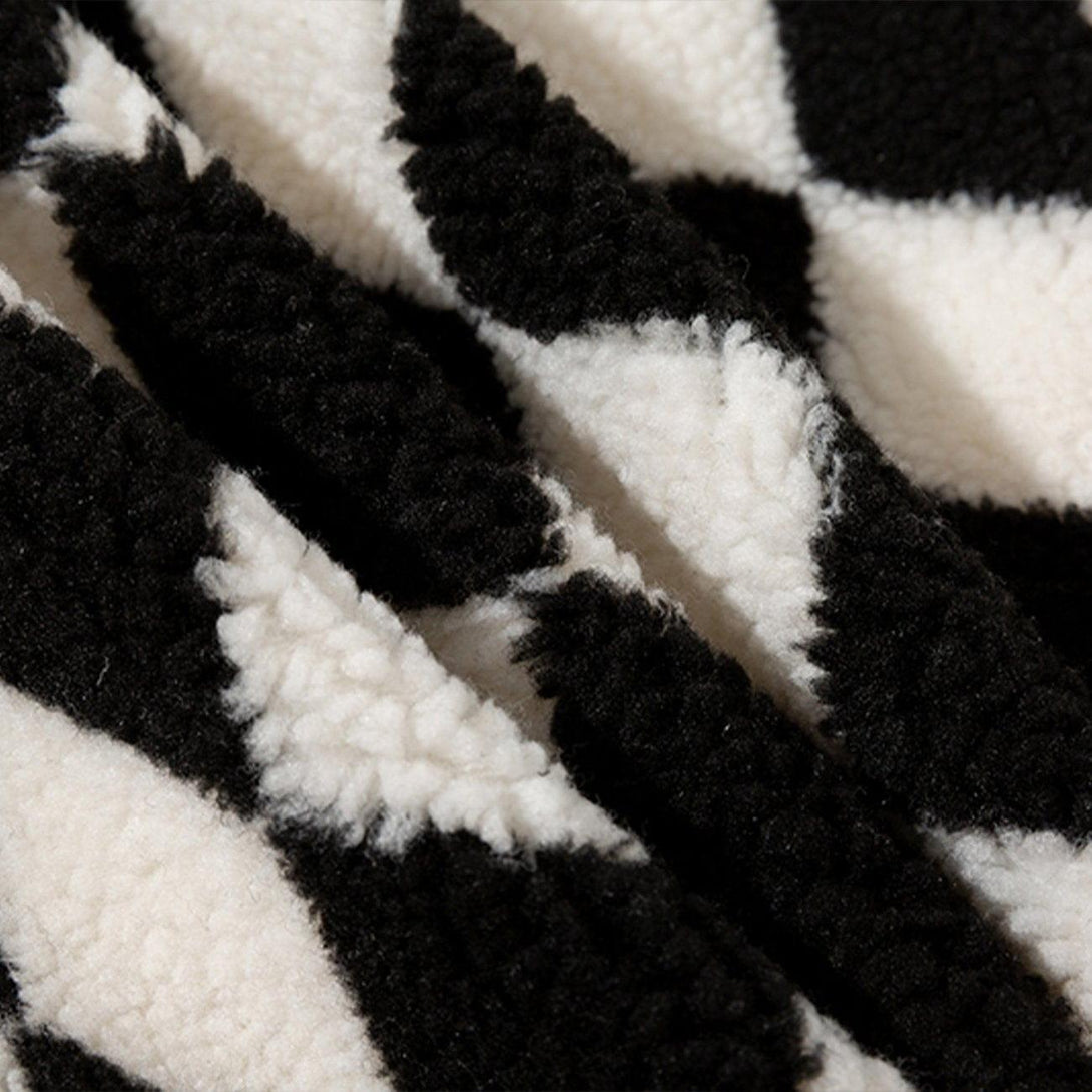 Zoomed-in texture of TALISHKO's sherpa coat, highlighting its black and white diamond pattern.