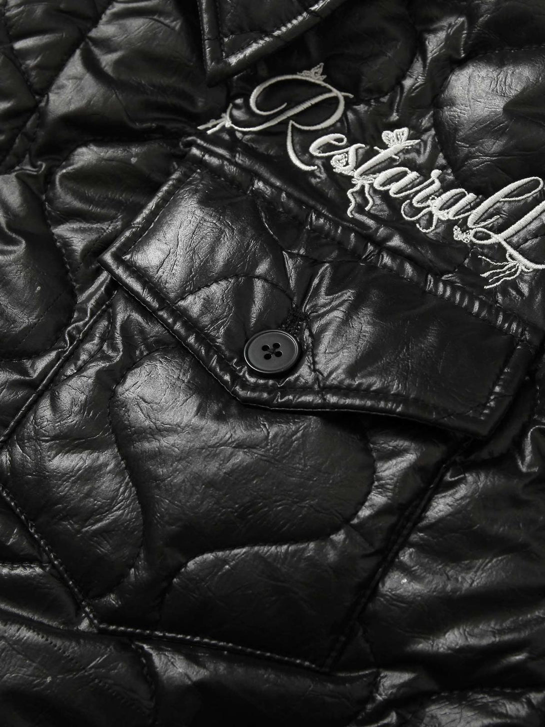 Intricate look at TALISHKO's diamond-quilted jacket, highlighting glossy texture and embroidery.