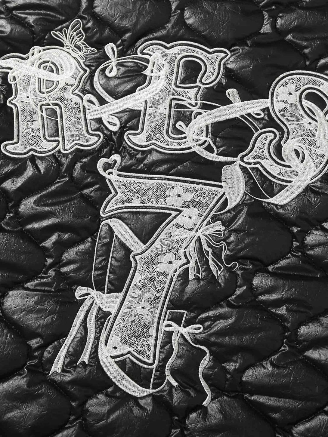 Intricate embroidery detail on TALISHKO's diamond-quilted jacket, showcasing texture and style.