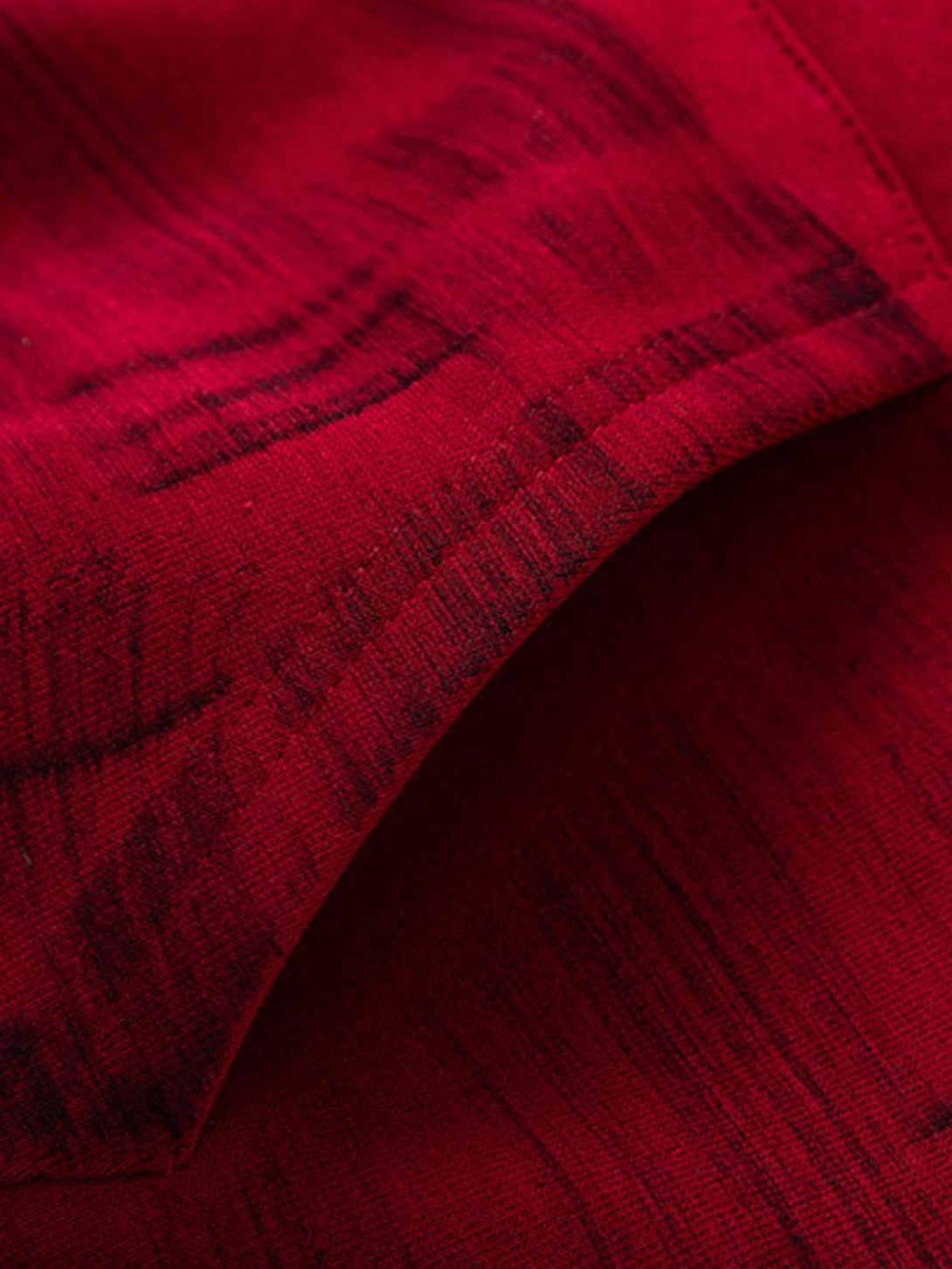 Zoomed-in texture of TALISHKO hoodie fabric, highlighting deep red brushstroke design.
