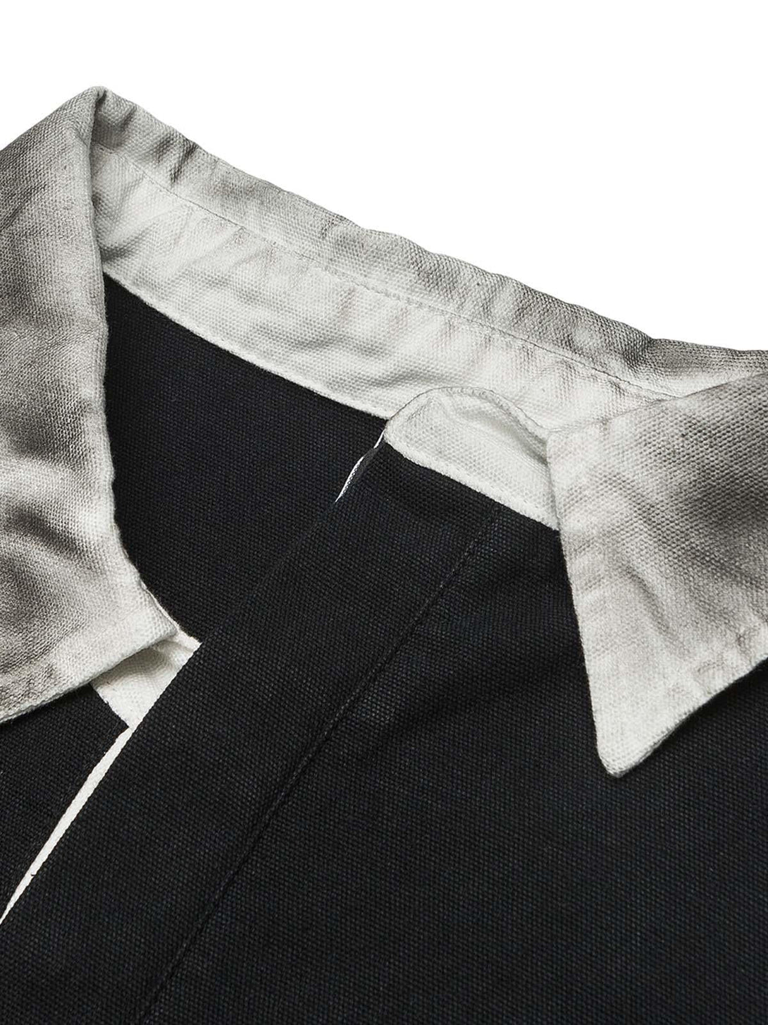 A detailed view of TALISHKO's dirty-dye polo collar, highlighting the intricate fabric texture.