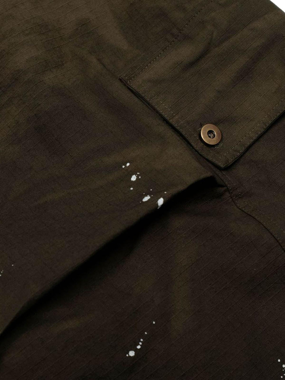 Focusing on the unique paint splatter design on TALISHKO distressed cargo jorts fabric.