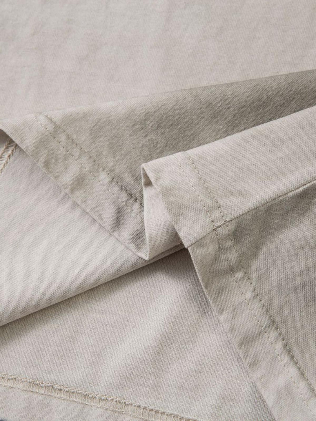 Intricate look at TALISHKO's dirty-dyed washed crew neck T-shirt fabric and stitching details.