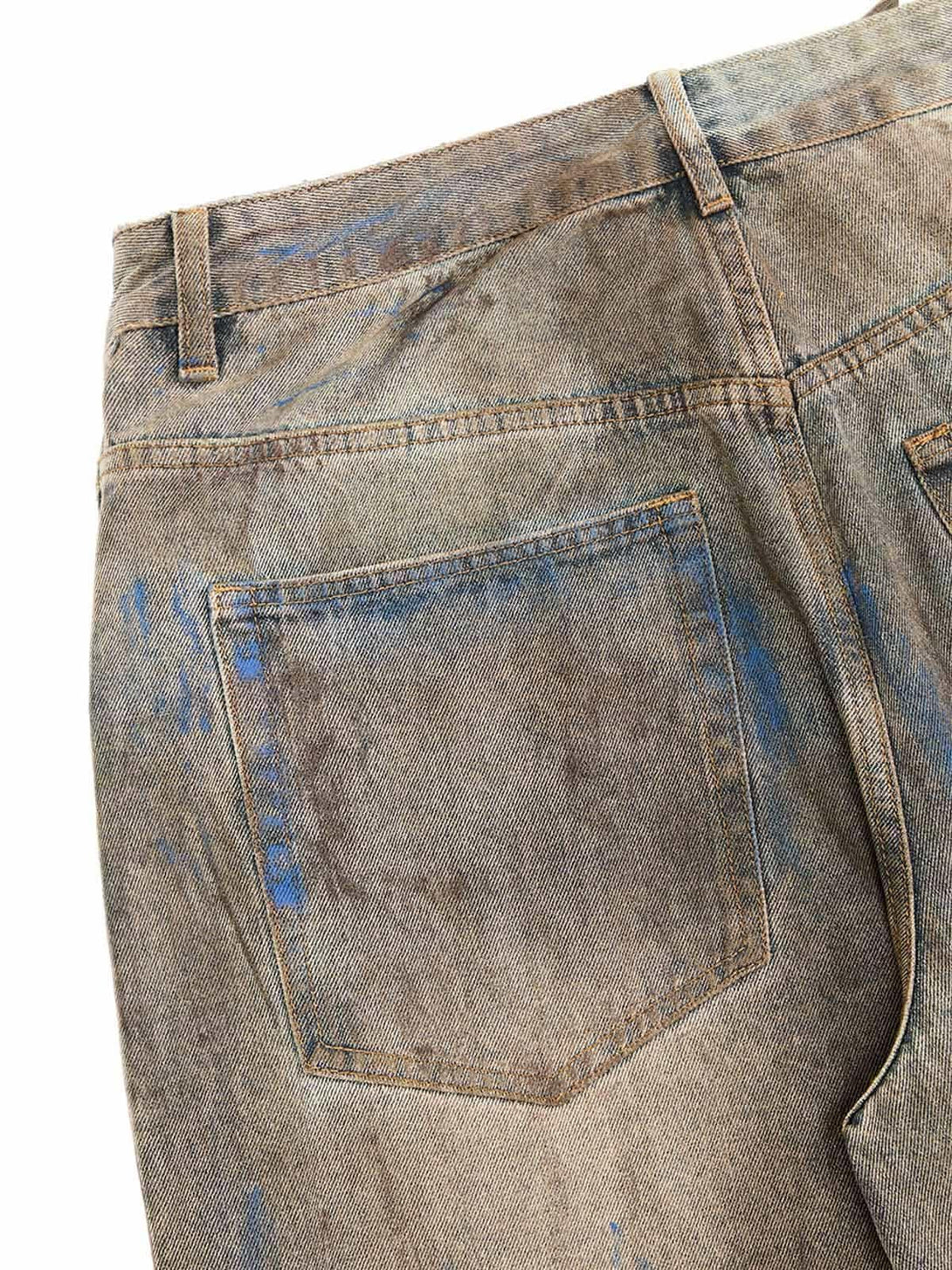A tight crop highlighting TALISHKO's dirty-dyed baggy jeans, focusing on the worn texture.