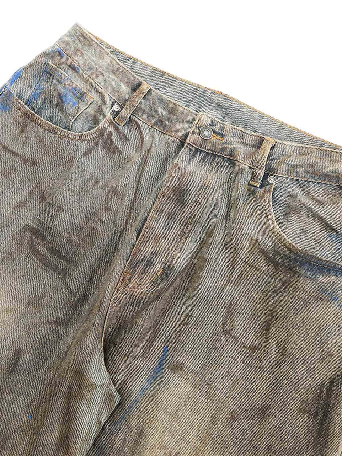 A detailed view of TALISHKO's dirty-dyed baggy jeans, highlighting their rugged texture.