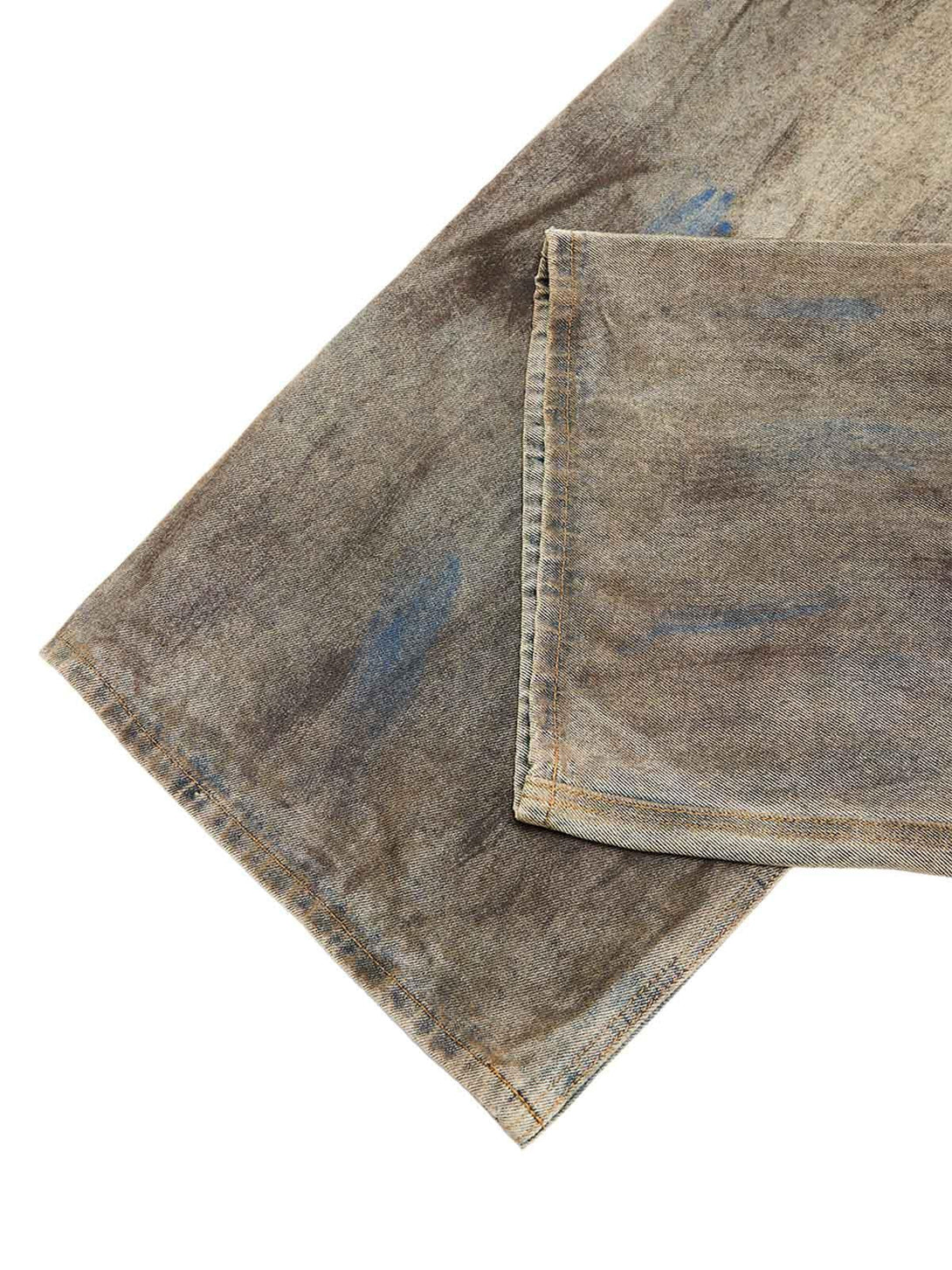 Intricate look at TALISHKO's dirty-dyed baggy jeans, emphasizing rugged fabric details.