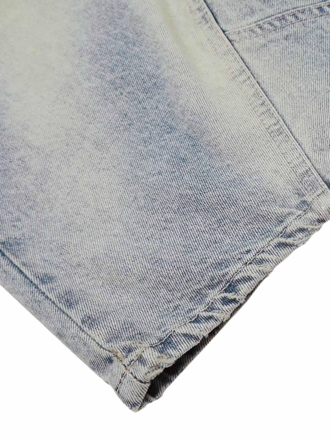A tight crop highlighting the distressed detail of TALISHKO baggy barrel jeans denim fabric.
