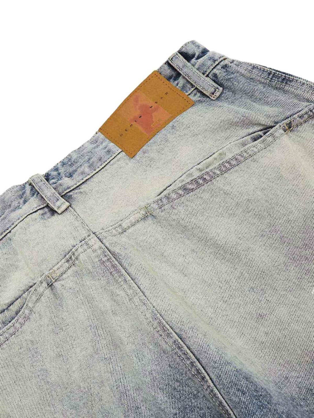 Focusing on the back detail of TALISHKO distressed baggy barrel jeans, highlighting faded denim.